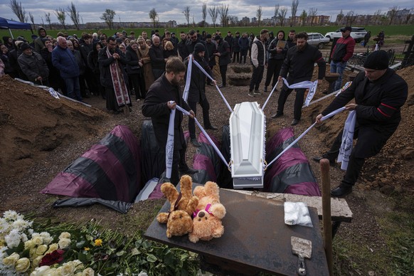 Funeral workers bury coffins of children Danylo Nikittskyi, 15, and Alina Kutsenko, 15, killed by a Russian missile, during a funeral ceremony in Kryvyi Rih, Ukraine, April 7, 2025. (AP Photo/Evgeniy  ...