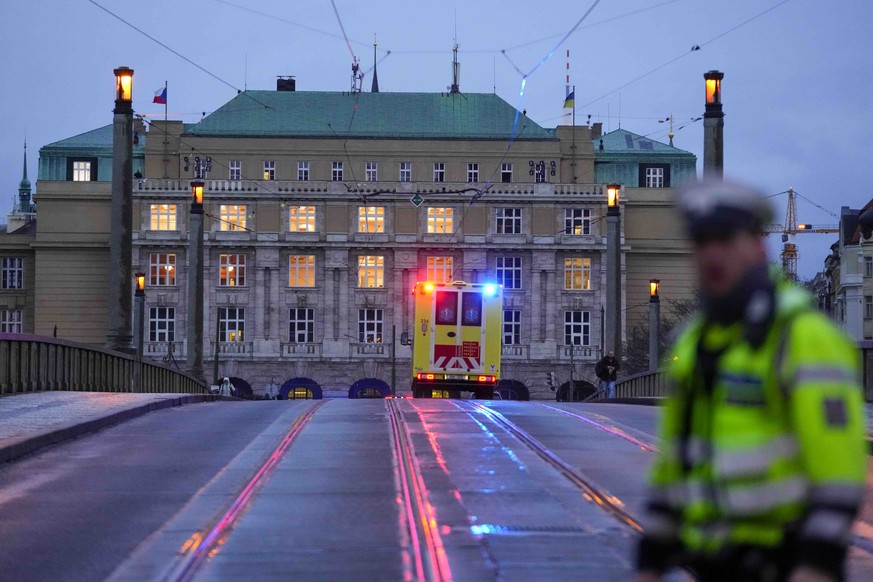 Une ambulance se dirige vers le bâtiment universitaire où a eu lieu le drame.