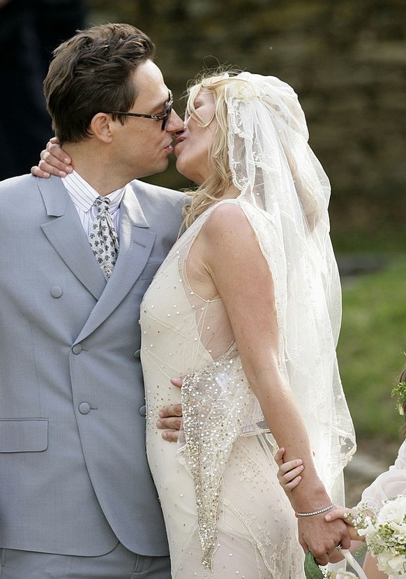SOUTHROP, UNITED KINGDOM - JULY 01: (EMBARGOED FOR PUBLICATION IN UK NEWSPAPERS UNTIL 48 HOURS AFTER CREATE DATE AND TIME) Jamie Hince and Kate Moss kiss as they leave St. Peter&#039;s Church after th ...
