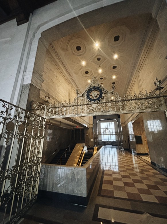 La mezzanine du premier étage, où se côtoient deux salles de bal et les anciens guichets de la banque.
