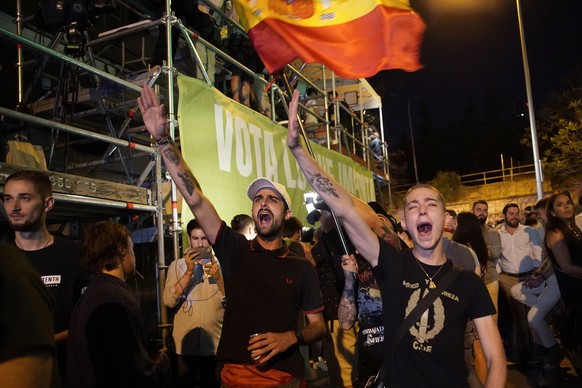 Des jeunes hommes font le salut fasciste devant le siège du parti d'extrême droite Vox à Madrid.