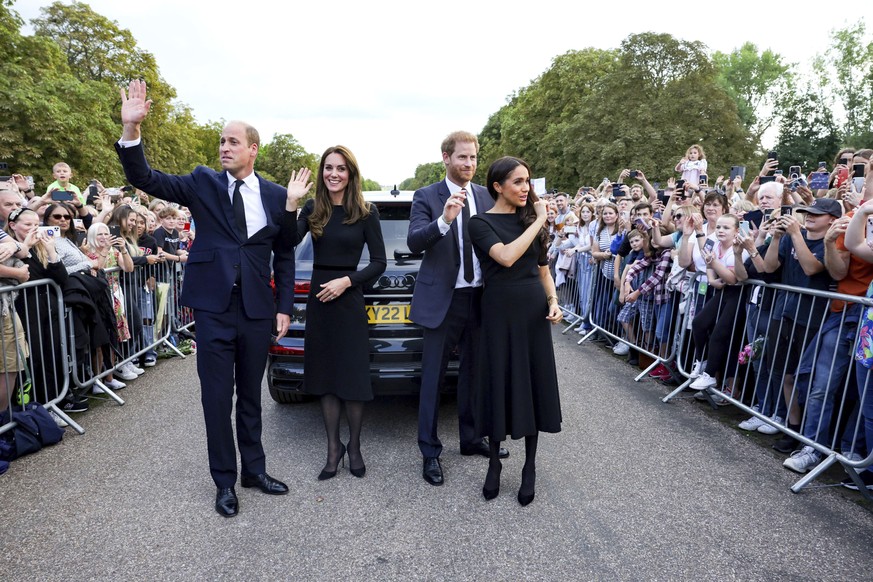 From left, Prince William, Prince of Wales, Kate, Princess of Wales, Prince Harry and Meghan, Duchess of Sussex, wave to members of the public at Windsor Castle, following the death of Queen Elizabeth ...