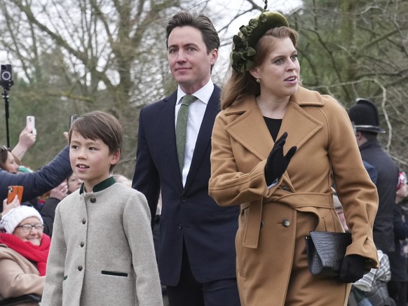 Princess Beatrice waves at the crowds with her husband Edoardo Mozzi and her stepson Christopher Wolf as they arrive for the Christmas day service at St Mary Magdalene Church in Sandringham in Norfolk ...