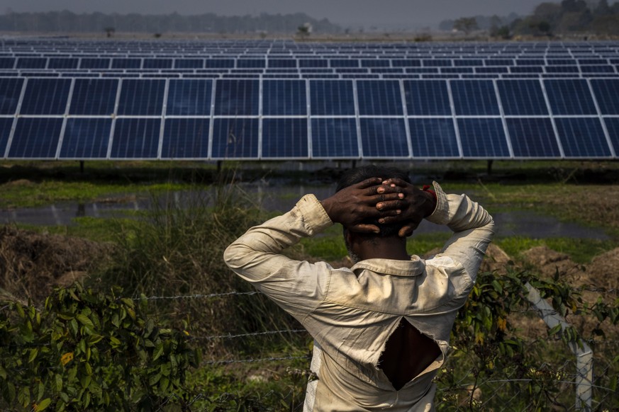 52-year old farmer Sitaram Murmu, whose agriculture land had been transfered to build a solar power plant stands near the plant in Mikir Bamuni village, Nagaon district, northeastern Assam state, Indi ...