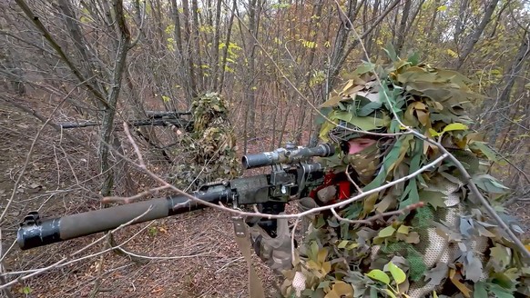 In this image made from video released by the Russian Defense Ministry on Thursday, Oct. 31, 2024, Russian snipers fire towards Ukrainian forces from an undisclosed location. (Russian Defense Ministry ...
