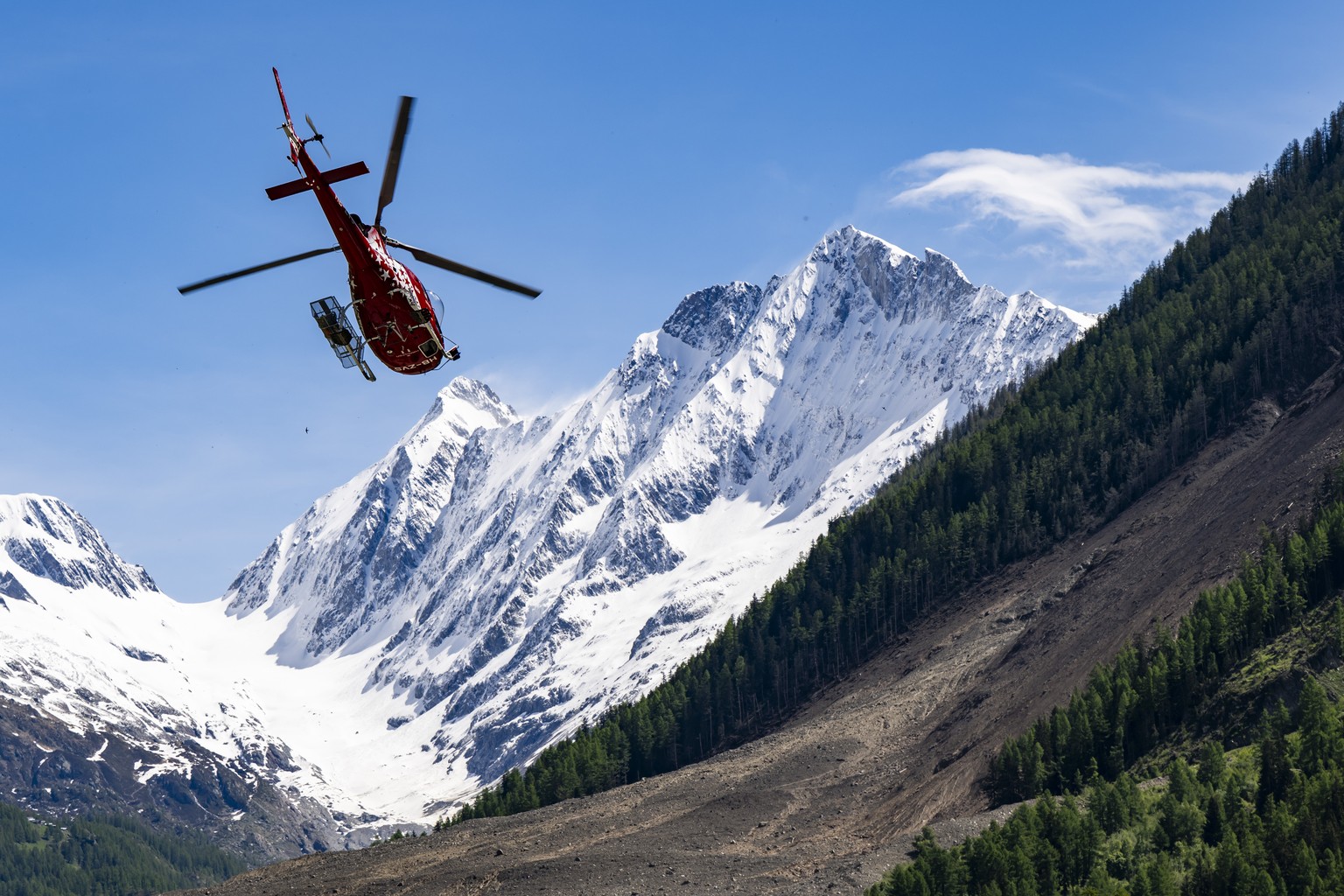epa12143237 Air Zermatt helicopter flies over the area one day after a massive avalanche, triggered by the collapse of the Birch Glacier, shows the destruction it caused as it swept down to the valley ...