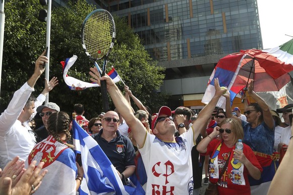 Fans of Serbian tennis star Novak Djokovic react to news of his overturned ruling outside Federal Court ahead of the Australian Open in Melbourne, Australia, Monday, Jan. 10, 2022. An Australian judge ...