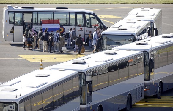 People disembark from a chartered plane and board waiting busses, after being evacuated from Afghanistan, during arrival at Melsbroek Military Airport in Melsbroek, Belgium, Wednesday, Aug. 25, 2021.  ...