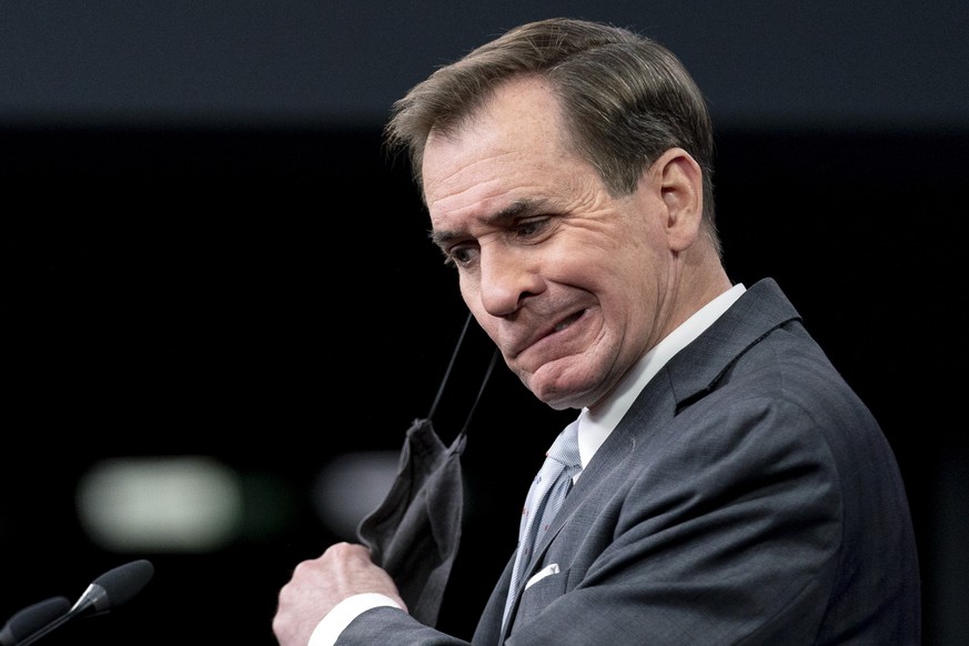 Pentagon spokesman John Kirby takes off his mask as he arrives for a briefing at the Pentagon in Washington, Wednesday, Feb. 2, 2022. President Joe Biden is sending about 2,000 troops from Fort Bragg, ...