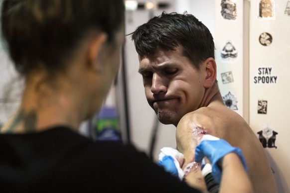 Nick Gallagher reacts as volunteer registered nurse Jennifer D'Angelo treats his skin wounds the Savage Sisters' community outreach storefront in the Kensington neighborhood of Philadelphia, ...