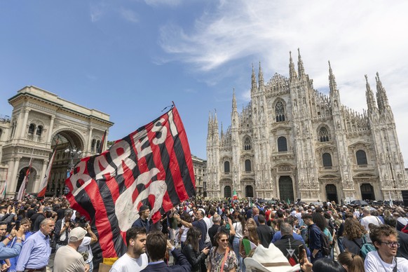 People wave an AC Milan flag with the name of former player Franco Baresi in front of Milan&#039;s Gothic Cathedral, ahead of former Italian premier Silvio Berlusconi?s state funeral, Italy, Wednesday ...