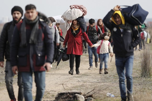 epa08262909 Refugees and migrants walk in a dirty road heading to the Turkish-Greek border and trying to enter Europe, in Edirne, Turkey, 01 March 2020. The Turkish government announced its decision t ...