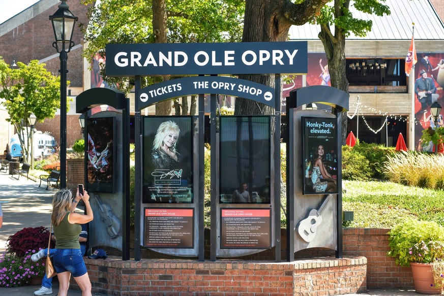 Nashville, TN, USA September 22, 2019 Tourists take pictures at entrance of The Grand Ole Opry House, a world famous concert hall dedicated to honoring country music and its history. One billboard adv ...
