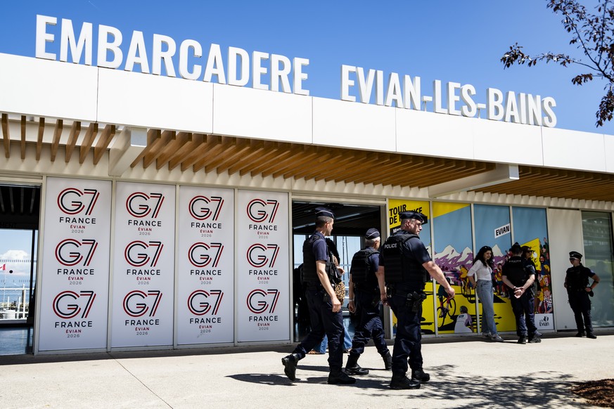epaselect epa13020181 French police officers walk in front of a G7 banner in Evian-les-Bains, France, 06 June 2026. The 52nd G7 Summit will take place from 15 to 17 June 2026 in Evian-les-Bains. It wi ...