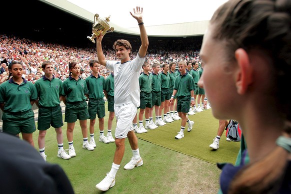 ARCHIV --- ZUM BERICHT �100 JAHRE CENTRE COURT WIMBLEDON� STELLEN WIR IHNEN FOLGENDES BILDMATERIAL ZUR VERFUEGUNG --- Roger Federer of Switzerland holds the championship trophy and waves to the crowd  ...