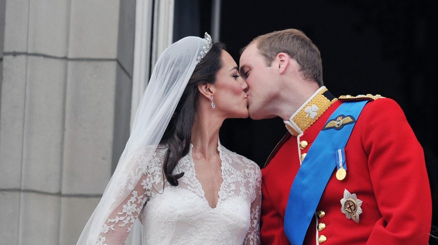 FILE- This Friday, April 29, 2011 file photo shows Prince William and his wife Kate Middleton, who has been given the title of The Duchess of Cambridge, as they kiss on the balcony of Buckingham Palac ...