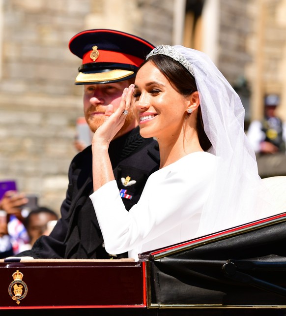 WINDSOR, ENGLAND - MAY 19: Prince Harry, Duke of Sussex and Meghan, Duchess of Sussex leave Windsor Castle in the Ascot Landau carriage during the procession after getting married at St George&#039;s  ...