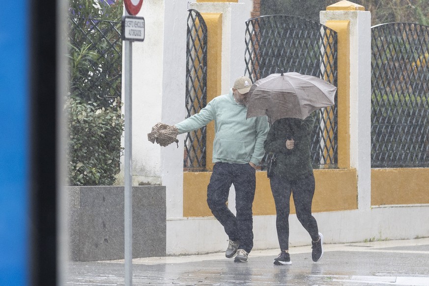 epa12712256 Two passers-by face a wind storm and rainfall in the city of Huelva, Andalusia, southwestern Spain, 07 February 2026. Local authorities are on alert for gusts of wind reaching up to 100 km ...