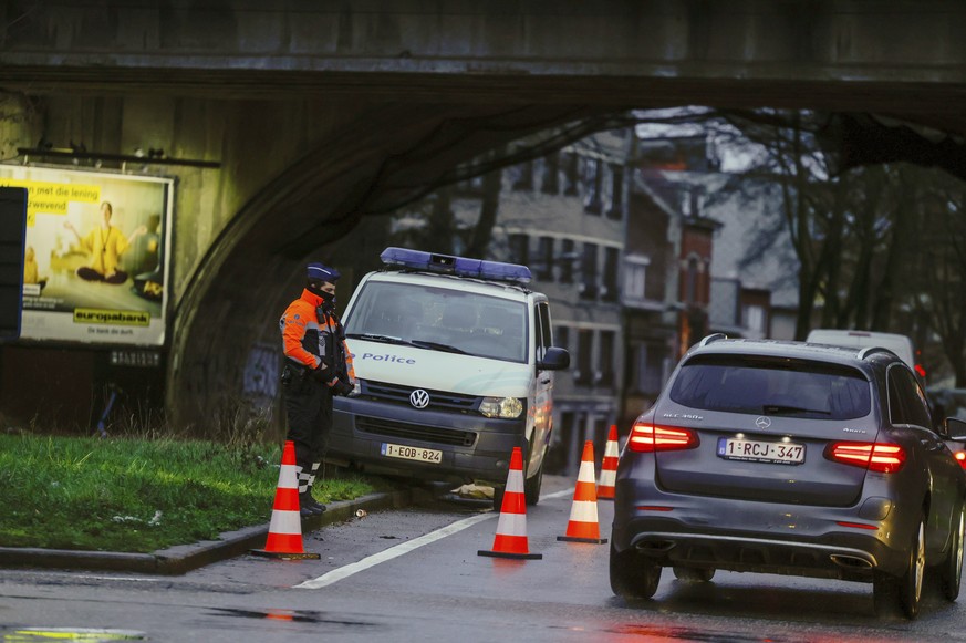 A police officer checks cars at a security point in Brussels, Monday, Feb. 14, 2022. Authorities in France and Belgium have banned road blockades threatened by groups organizing online against COVID-1 ...