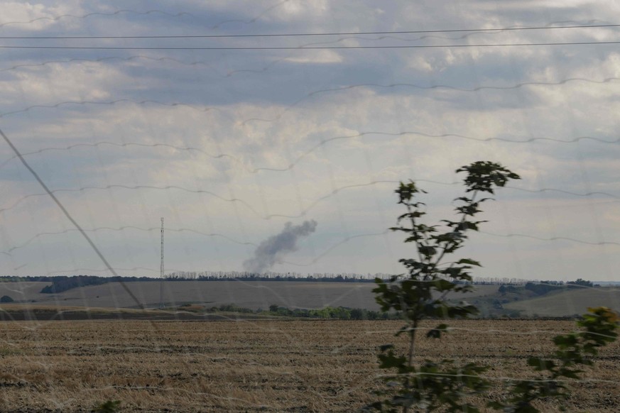 Une colonne de fumée noire s'élève au-dessus des champs agricoles et d'une lisière de forêt dans l'oblast de Kharkiv, en Ukraine, le 12 août 2026.