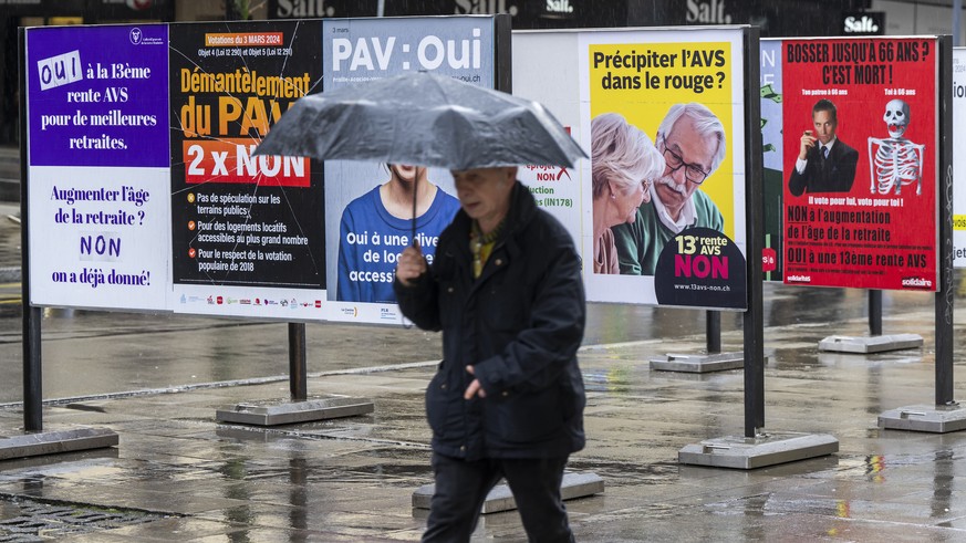 Un personne passe devant des affiches des partis politiques et des associations donnant leurs mots d&#039;ordre pour les votations federales et cantonales du 3 mars, ce jeudi 22 fevrieir 2024 a Geneve ...