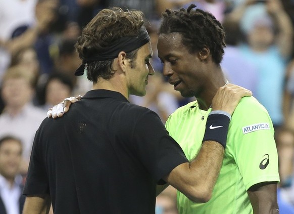 Gael Monfils, right, of France, meets at the net with Roger Federer, of Switzerland, after their quarterfinal at the U.S. Open tennis tournament, Thursday, Sept. 4, 2014, in New York. Federer won 4-6, ...