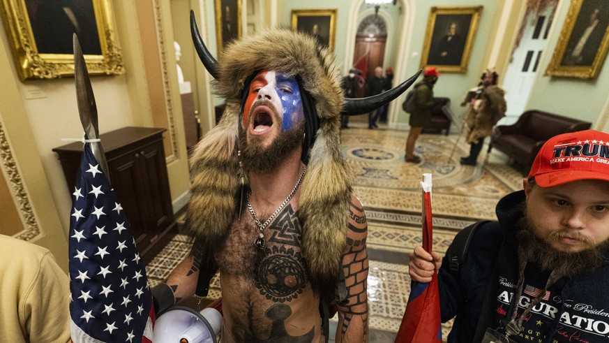 Jacob Anthony Chansley, center, with other insurrectionists who supported then-President Donald Trump, are confronted by U.S. Capitol Police in the hallway outside of the Senate chamber in the Capitol ...