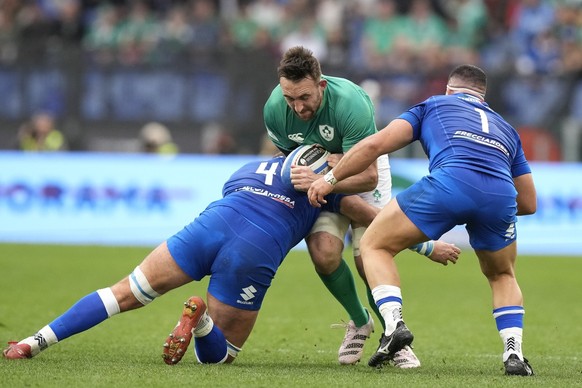 Ireland&#039;s Jack Conan is tackled by Italy&#039;s Niccolo Cannone, left, and Italy&#039;s Danilo Fischetti during the Six Nations rugby union international match between Italy and Ireland, at Rome& ...