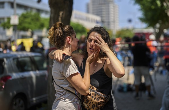 KEYPIX - People react next to the site of a direct missile strike launched from Iran in Tel Aviv, Israel, on Sunday, June 22, 2025. (KEYSTONE/AP Photo/Bernat Armangue)