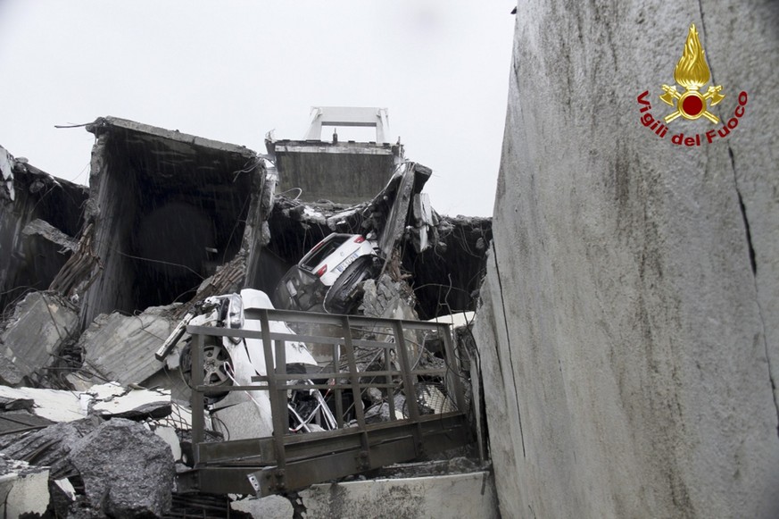 This photo released by the Italian firefighters, cars are seen among the rubble of the collapsed Morandi highway bridge in Genoa, northern Italy, Tuesday, Aug. 14, 2018. A large section of the bridge  ...