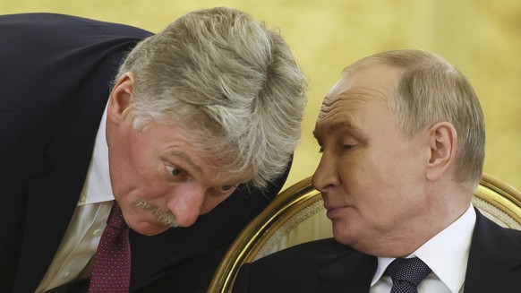 Russian President Vladimir Putin, right, speaks with Kremlin spokesman Dmitry Peskov during an extended meeting at the summit of the heads of state of the Commonwealth of Independent States (CIS) at t ...
