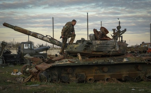 A Ukrainian soldier inspects a damaged Russian tank in the recently retaken village Chornobaivka near Kherson, Ukraine, Tuesday, Nov. 15, 2022. (AP Photo/Efrem Lukatsky)