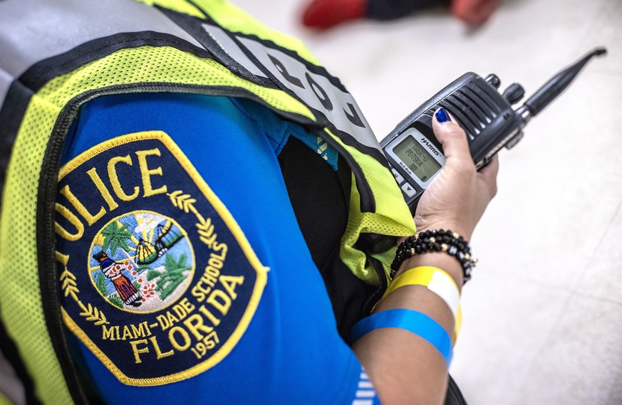 epa10800208 A Miami-Dade School Police officer holds a police radio during a functional active shooter drill at the Miami Senior High School, in Miami, Florida, USA, 14 August 2023. According to the o ...