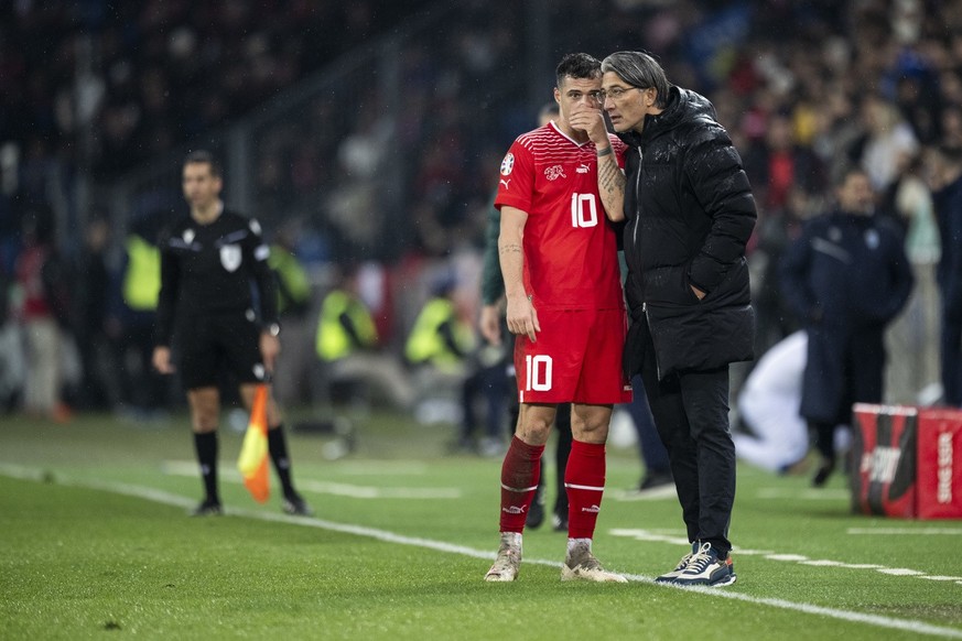 Switzerland's head coach Murat Yakin speaks with Granit Xhaka during the UEFA Euro 2024 qualifying group I soccer match between Switzerlandat and Kosovo at the St. Jakob-Park stadium in Basel, Sw ...