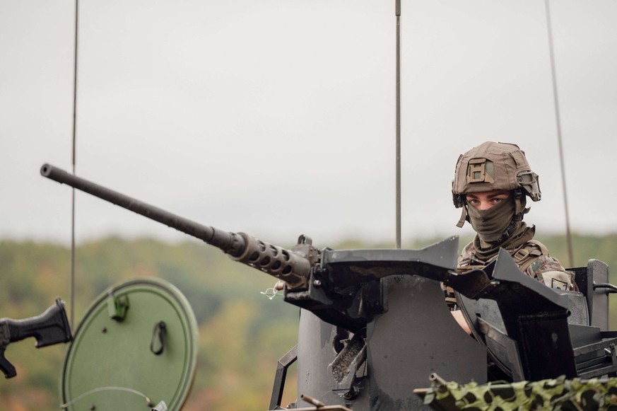 Un soldat dans une mitrailleuse montée sur un véhicule blindé.