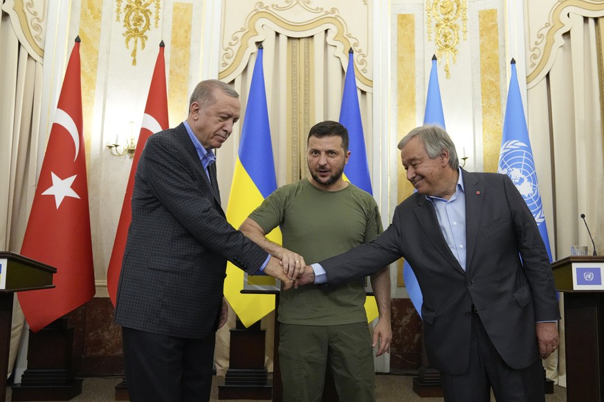 Ukrainian President Volodymyr Zelenskyy, center, Turkish President Recep Tayyip Erdogan, left, and United Nations Secretary General Antonio Guterres shake hands after their meeting in Lviv, Ukraine, T ...