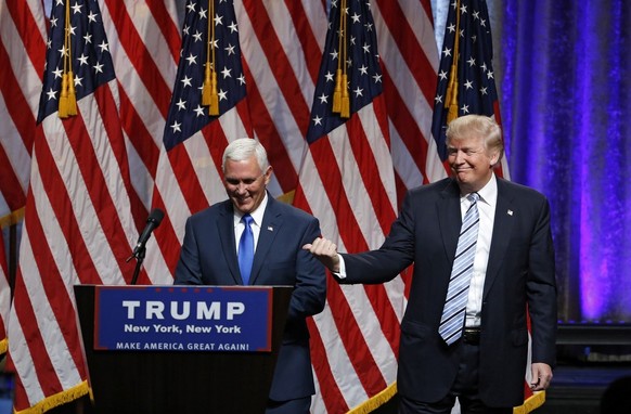 epa05428240 US Republican presidential candidate Donald Trump (R) introduces his pick for Vice President Indiana Governor Mike Pence (L) during their announcement at the New York Hilton Hotel Grand Ba ...