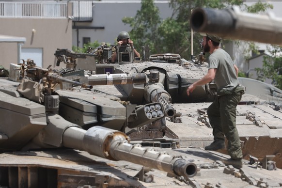 epa11357605 Israeli soldiers with their tanks gather at an undisclosed location near the border fence with the Gaza Strip, in southern Israel, 21 May 2024. The Israeli military stated on 21 May that t ...