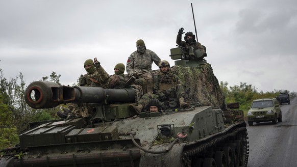 Ukrainian servicemen drive atop a self-propelled artillery vehicle in the recently retaken area of Dolyna, Donetsk region, Ukraine, Wednesday, Sept. 14, 2022. (AP Photo/Evgeniy Maloletka)