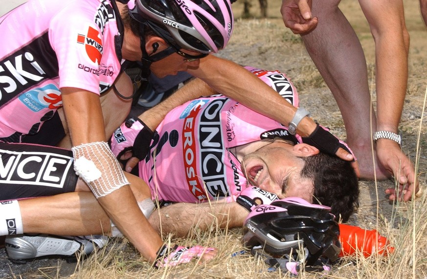 Jose Azevedo vient soutenir son leader, Joseba Belok après sa terrible chute. Le Tour de France 2003 a basculé le 14 juillet. (AP Photo/Bruno Fablet/Pool)