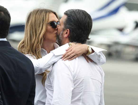 U.S. President Donald Trump's son Donald Trump Jr kisses his partner Bettina Anderson as they wait for the arrival of U.S. President Donald Trump at Teterboro Airport in Teterboro, New Jersey, U. ...