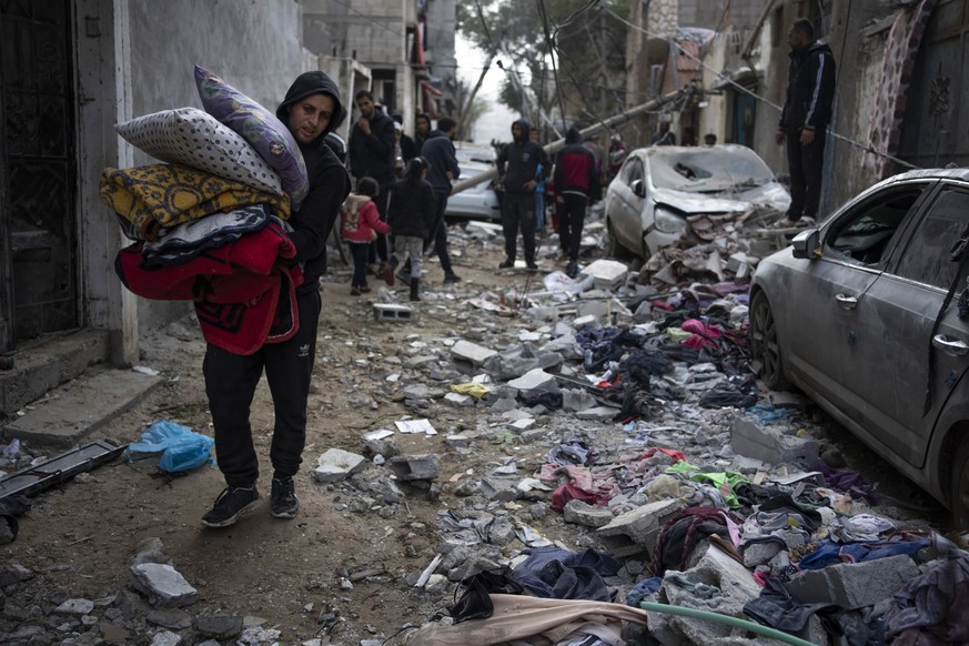 Palestinians look at the destruction after an Israeli airstrike in Rafah, Gaza Strip, Friday, Feb. 9, 2024. (AP Photo/Fatima Shbair)