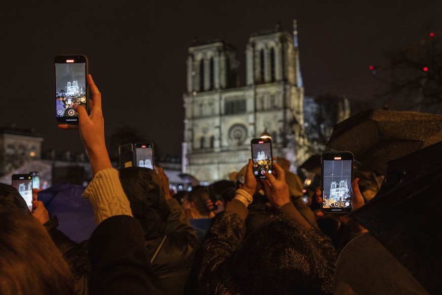 Spectators take snapshots outside France&#039;s iconic Notre Dame Cathedral Saturday, Dec. 7, 2024 in Paris during it&#039;s formal reopening for the first time since a devastating fire nearly destroy ...