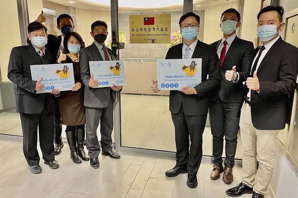 FILE - In this file photo released by the Taiwan Ministry of Foreign Affairs, Eric Huang, newly appointed director to the representative office, third from right, poses with other staffers outside the ...