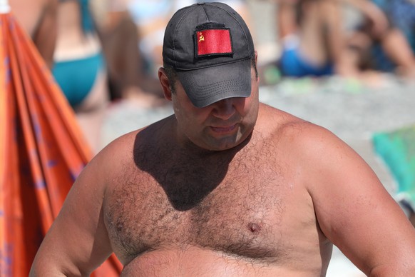 epa10778096 A man wearing a cap with former Soviet Union Red flag rests at a Black Sea beach in Alushta, Crimea, 24 July 2023 (issued 31 July 2023). Crimea was annexed by Russia in 2014, shortly after ...