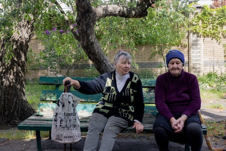 Valentyna Romenska (à gauche) et Lidia Isayeva (à droite) assises sur un banc devant un bâtiment lourdement endommagé dans la ville de Lyman, près de la ligne de front dans la région de Donetsk, le 7  ...
