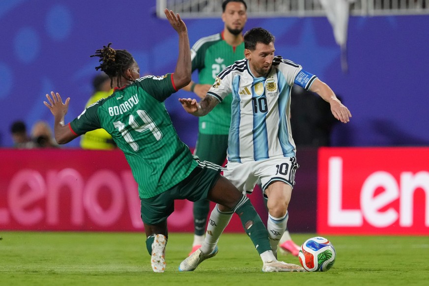 Argentina's Lionel Messi (10) battles for the ball with Algeria's Hicham Boudaoui (14) during the World Cup Group J soccer match between Argentina and Algeria in Kansas City, Mo., Tuesday, J ...