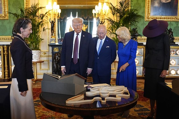 WINDSOR, ENGLAND - SEPTEMBER 17: US President Donald Trump, King Charles III, Queen Camilla and First Lady Melania Trump view items on display during a visit to the Royal Collection exhibition, in the ...