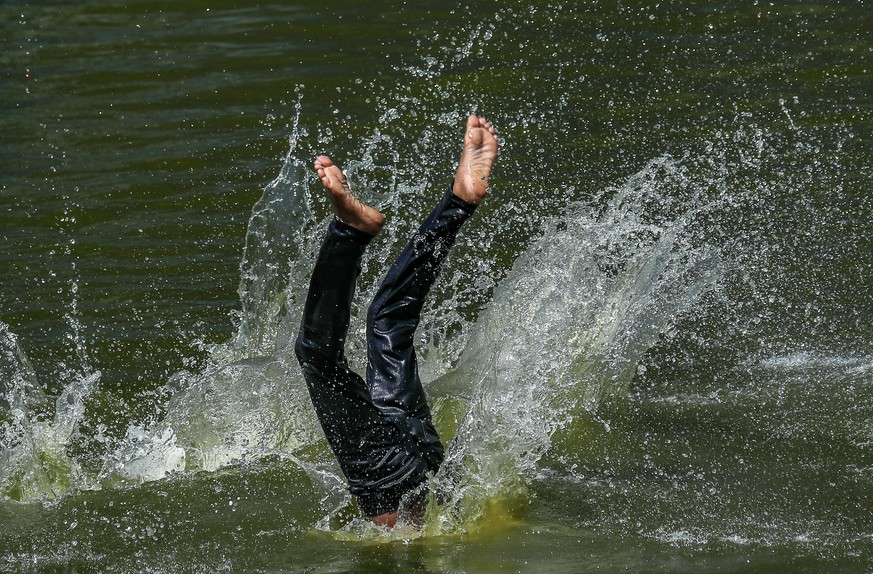 epa09920091 An Indian boy jumps into a pond to refresh during a hot afternoon in Mumbai, India, 01 May 2022. Large parts of India are experiencing the hottest April on record. According to the India M ...