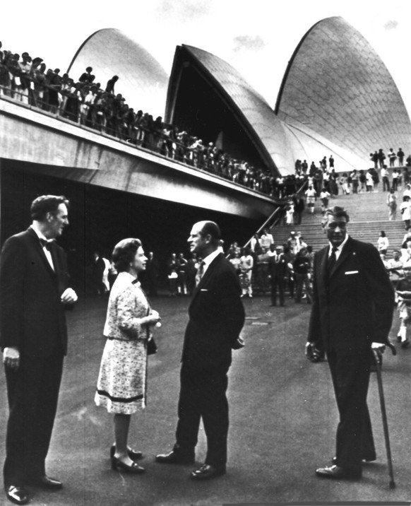 Britain&#039;s Queen Elizabeth II, talks to her husband Prince Philip, before the new Sydney Opera House complex, Sydney, Oct. 20, 1973. Left is Frank Barnes, General Manager of the Opera House and ri ...